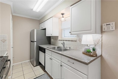 Kitchen with ornamental molding, white cabinets, range with electric cooktop, light tile patterned floors, and tasteful backsplash