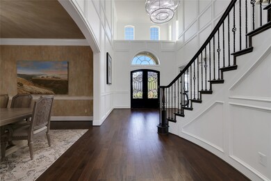 Gorgeous double doors, high ceilings, & custom wood paneling in the entry.