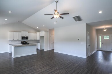 Kitchen with light stone counters, white cabinets,