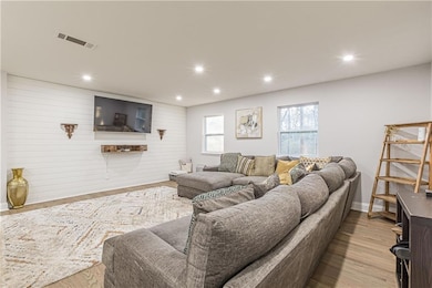 Living area with wood finished floors, baseboards, and recessed lighting