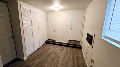 Hall with baseboards and dark wood-style flooring