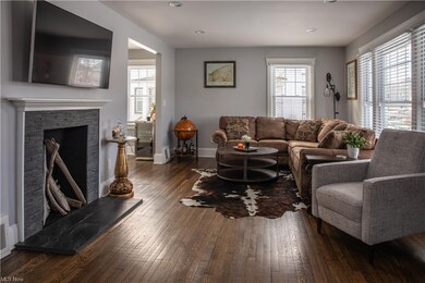 The living room features refinished wood floors and a modern fireplace.