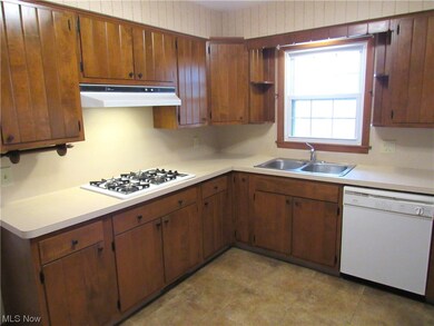 Kitchen featuring white appliances, light tile floors, and sink
