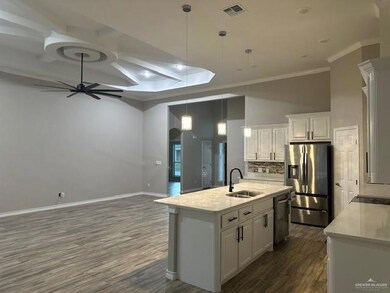 Kitchen with appliances with stainless steel finishes, white cabinets, visible vents, ceiling fan, and a sink