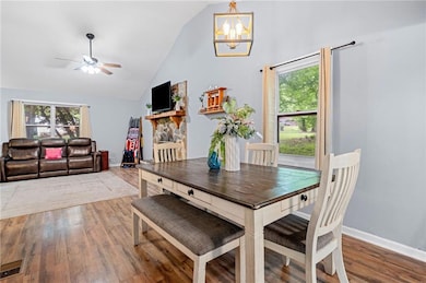 Dining room with wood finished floors, a chandelie