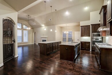 Functional living with the double island kitchen open to the living room and breakfast area.  Dry bar/wine storage is located behind the iron gate.