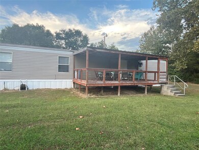 Rear view of house featuring a wooden deck and a y