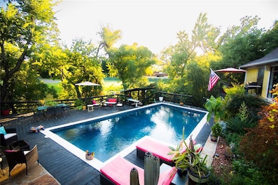 View of pool featuring a wooden deck and outdoor dining area