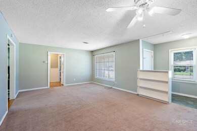 Carpeted spare room featuring a textured ceiling, 