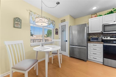 Kitchen featuring white cabinets, light wood-type flooring, appliances with stainless steel finishes, and a toaster