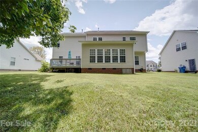 Rear view of spacious deck and sun filled sunroom.