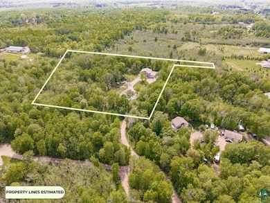 Aerial overview of property's location featuring a heavily wooded area and property parcel outlined