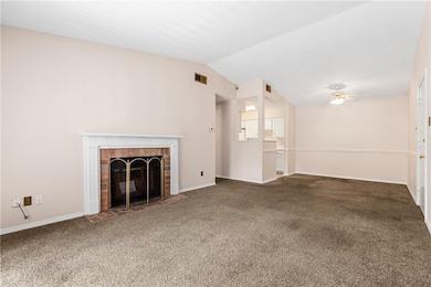 Unfurnished living room featuring ceiling fan, carpet floors, a fireplace, and lofted ceiling