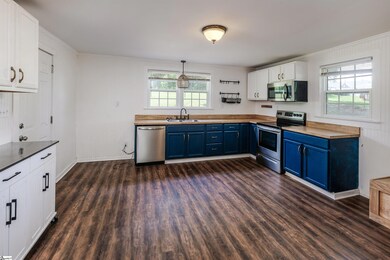 Spacious kitchen with butcher block counters, stainless appliances, built-in bench seating with storage.