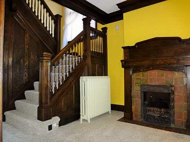 Entry/Foyer. The brick fire place and wooden stair
