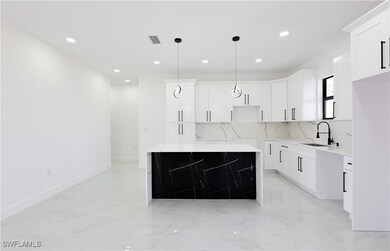Kitchen with a sink, light marble finish floors, r