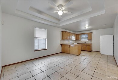 Kitchen with backsplash, white appliances, and a tray ceiling