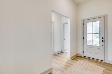 Entryway featuring baseboards and light wood-style flooring