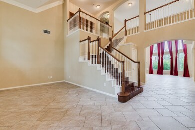 The dramatic two story entryway with a view of the beautiful staircase, catwalk and  the Family Room.