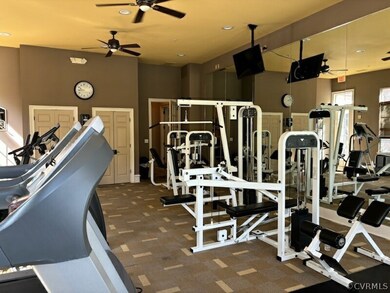 Gym featuring ceiling fan and dark carpet