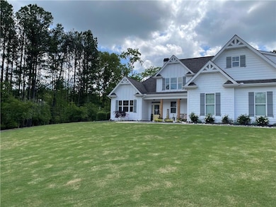 View of front of house with board and batten siding, a front lawn, a porch, and roof with shingles