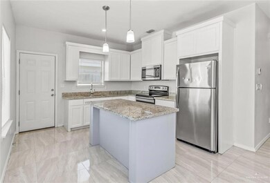 Kitchen with visible vents, a center island, white cabinetry, a sink, and appliances with stainless steel finishes