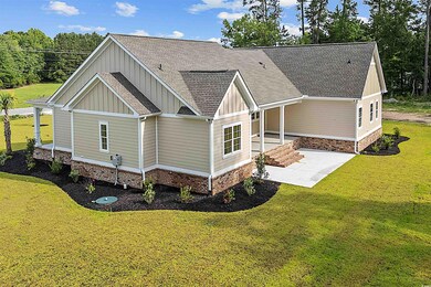 Rear view of property featuring board and batten siding, a shingled roof, and a yard