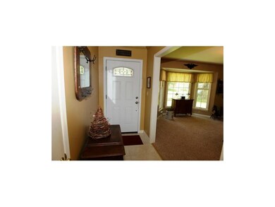 Tiled entry and carpeted living room.