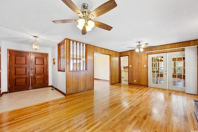Interior space featuring a ceiling fan, wood walls