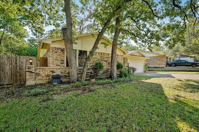 View of front of home with brick siding, driveway, and an attached garage