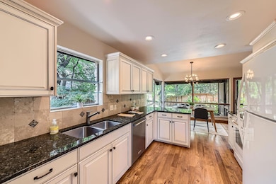 Kitchen with white appliances, light wood-style f