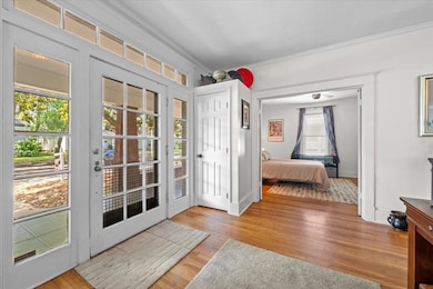 Bedroom featuring crown molding, access to outside, and wood finished floors