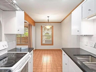 Kitchen with white electric range oven, a sink, e