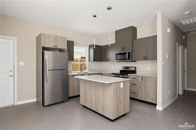 Kitchen featuring pendant lighting, a center island, light tile patterned floors, and stainless steel appliances