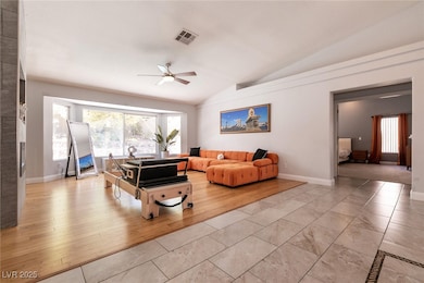 Living area with vaulted ceiling, ceiling fan, and