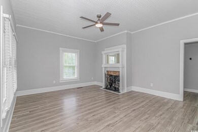 Unfurnished living room featuring crown molding, l