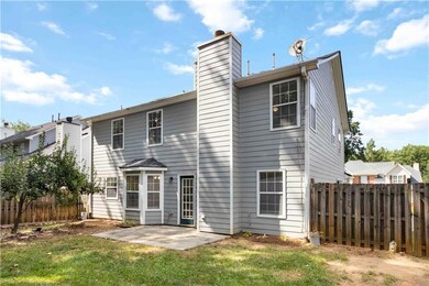 Rear view of house featuring a chimney and a patio