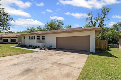 Ranch-style house with a front lawn, driveway, fen