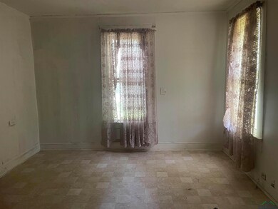 Spare room with baseboards and light floors