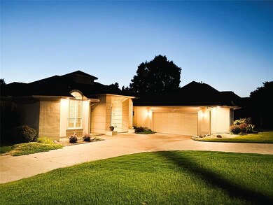 Ranch-style house with driveway, a front lawn, an attached garage, and stucco siding