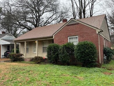 View of side of home with a porch and a lawn