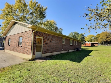 View of home's exterior with a lawn and brick siding