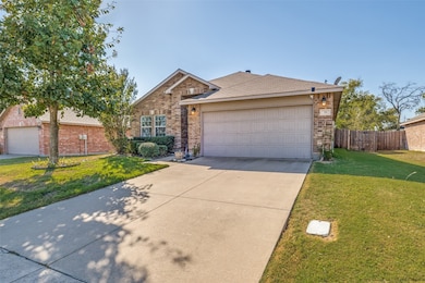 View of front of house with driveway, a shingled roof, brick siding, and a garage
