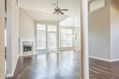 Unfurnished living room with a tiled fireplace, vi