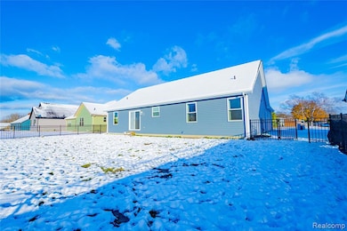 Snow covered house featuring a fenced backyard
