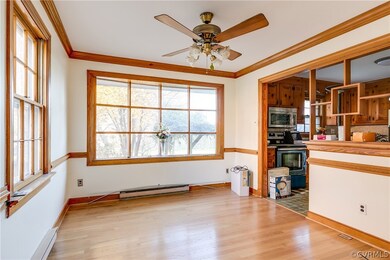 Formal dining room has ceiling fan, overhead light, crown moulding, chair rail, and beautiful bow window overlooking rear yard.