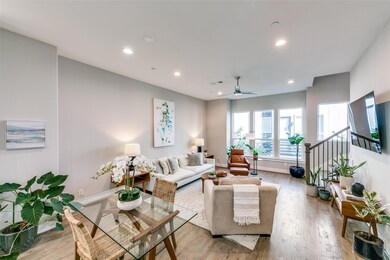 Living room featuring ceiling fan and light wood-t