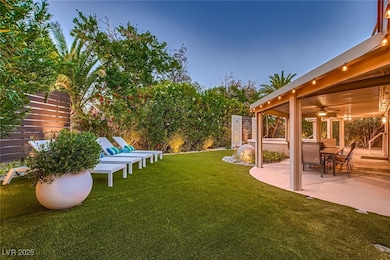 View of grassy yard featuring a patio area