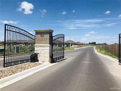 View of asphalt street with curbs, a gated entry, and a gate