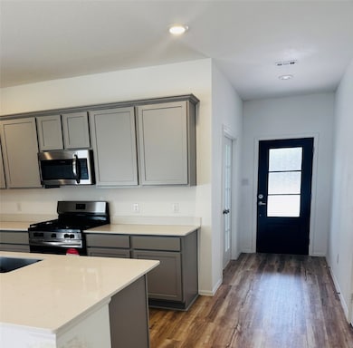 This kitchen features modern gray cabinetry, a sta